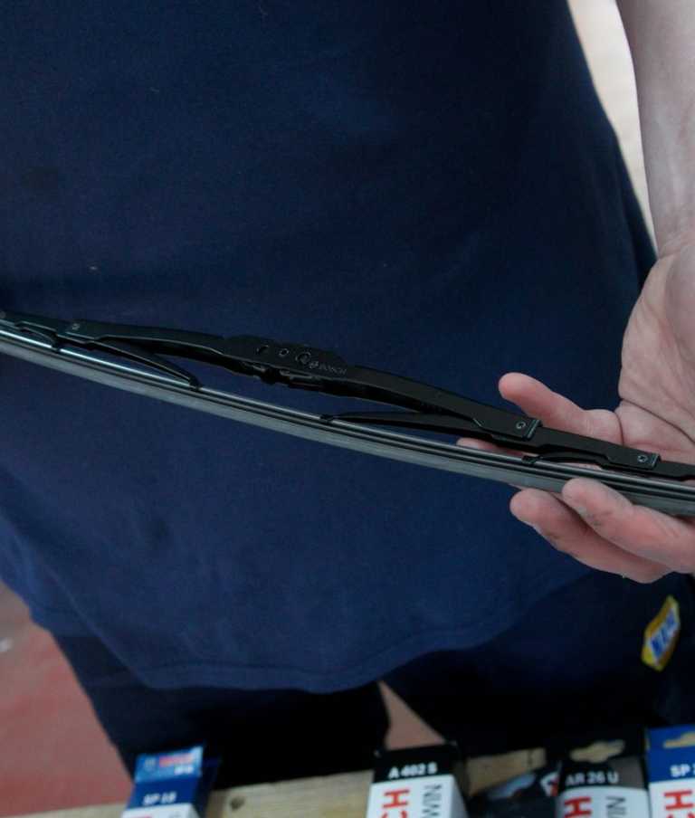 Male member of staff holding black wiper blade